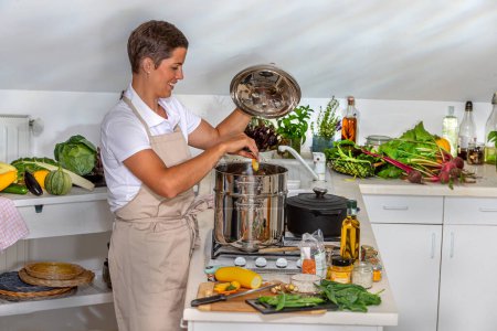 Woman filling pressure cooker with vegetables