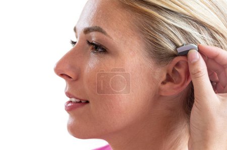 Close-up of fitting a hearing aid at the audiologist.