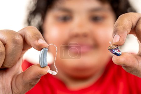 Photo for 14 year old boy choosing between two different hearing aids. - Royalty Free Image