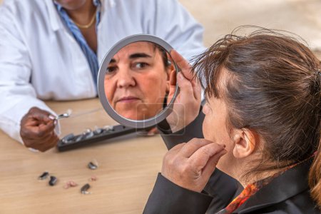 Photo for Patient trying different types of hearing aids. - Royalty Free Image