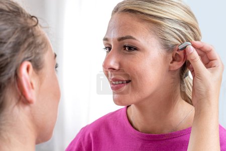 Photo for Close-up of fitting a hearing aid at the audiologist. - Royalty Free Image