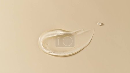 Cosmetic transparent gel serum swatch with bubbles isolated on beige background. Texture moisturizing gel of hyaluronic acid closeup. Face or body natural skin care products mug #655280594