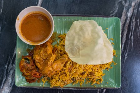 Téléchargez les photos : Vue du dessus du riz biryani avec poulet au curry et papadam - en image libre de droit