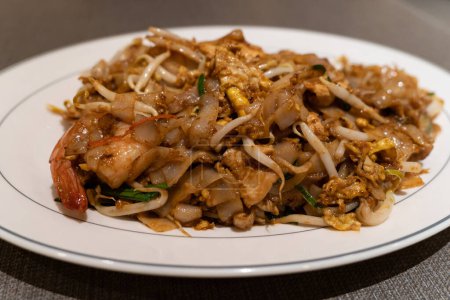 Photo for Fried Char Kway Teow is a stir-fried rice noodle dish popular food in Malaysia and Singapore. - Royalty Free Image