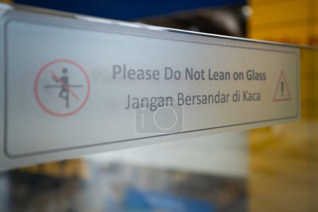 "Please Do Not Lean On Glass" sticker on the glass railing.