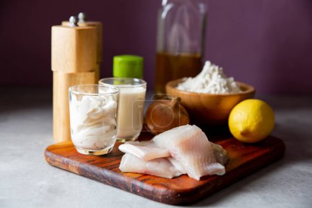 Ingredients for cooking whitefish fillet on kitchen counter.