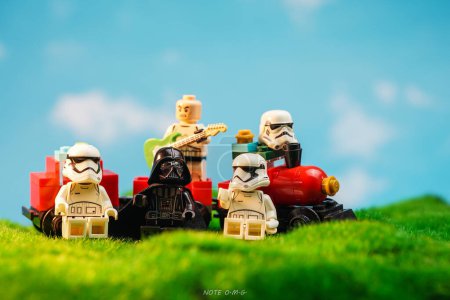 Photo for Bangkok, Thailand - October 3, 2022: Star Wars Lego Stormtroopers, Darth Vader and guitarist minifigures near red train against nature background. - Royalty Free Image