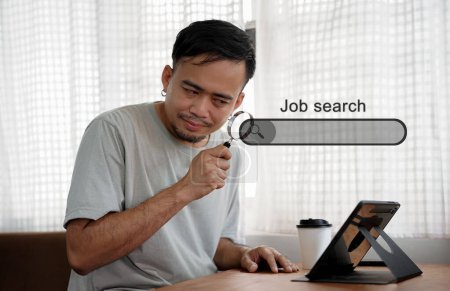 Photo for Asian man holding magnifying glass and looking at search bar with job search inscription - Royalty Free Image