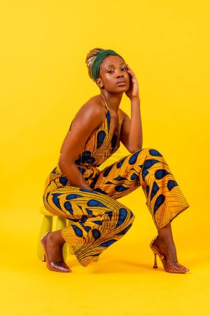 Afrikanische junge Frau in traditioneller Kleidung auf gelbem Hintergrund, verführerischer Look