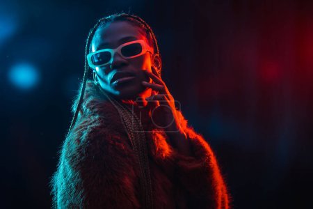 Black ethnic woman with braids with blue and red led lights, portrait in fur coat