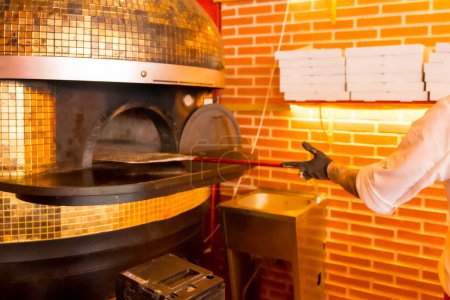 Téléchargez les photos : Four à pizza artisanal. Chef présentant avec la pelle, pizza chaude et prête pour les clients - en image libre de droit