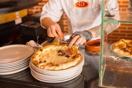 Téléchargez les photos : Four à pizza artisanal. Chef préparant la pizza pour la vendre, pizza chaude et prête pour les clients - en image libre de droit