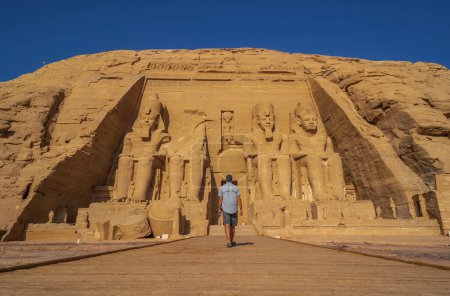 A young man walking towards the Abu Simbel Temple in southern Egypt in Nubia next to Lake Nasser. Temple of Pharaoh Ramses II, travel lifestyle