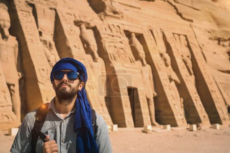 A young man wearing a blue turban visiting the Egyptian Temple of Nefertari near Abu Simbel in southern Egypt in Nubia next to Lake Nasser. Temple of Pharaoh Ramses II, travel lifestyle