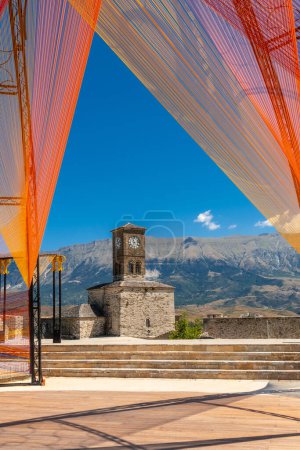 Photo for Colored arches in the Ottoman Castle Fortress of Gjirokaster or Gjirokastra and in the background the church with the clock tower. Albania, Kulla e Sahatit - Royalty Free Image