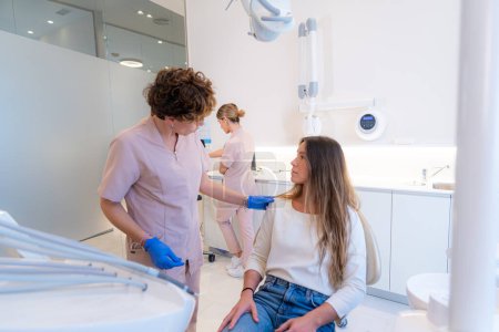 Foto de Comunicación entre un dentista y una mujer en la clínica - Imagen libre de derechos