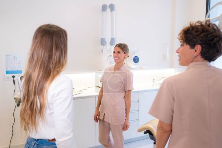 Zwei Mitarbeiter der Zahnklinik und ein Kunde im Gespräch in einem Raum