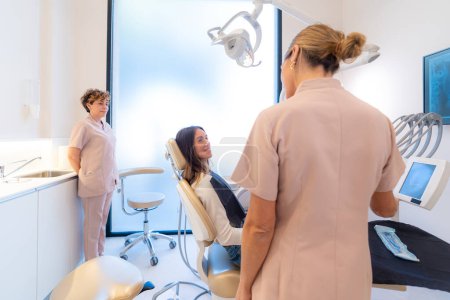 Foto de Vista trasera de un dentista explicando el procedimiento a un paciente - Imagen libre de derechos