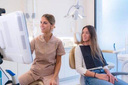 Foto de Cliente y dentista mirando los resultados en una pantalla en una clínica dental moderna - Imagen libre de derechos
