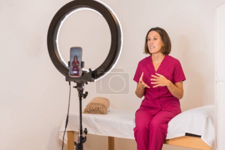 Foto de Foto horizontal con enfoque en un médico nutricionista durante una transmisión en vivo en casa - Imagen libre de derechos