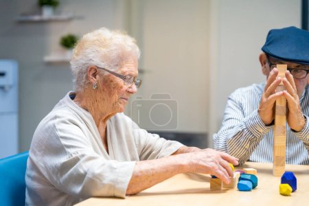 Foto de Anciana y hombre en un hogar de ancianos jugando juegos de habilidad - Imagen libre de derechos