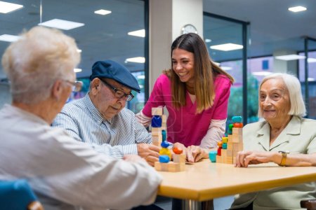 Linda enfermera en unirofm animando a las personas mayores a jugar juegos de habilidad en un hogar de ancianos