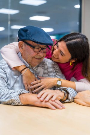 Foto de Foto vertical de un tierno momento de una enfermera abrazando a un anciano en un geriátrico - Imagen libre de derechos