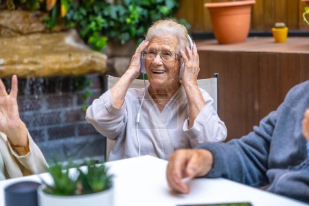 Foto de Personas mayores felices usando auriculares y divirtiéndose en un hogar de ancianos - Imagen libre de derechos