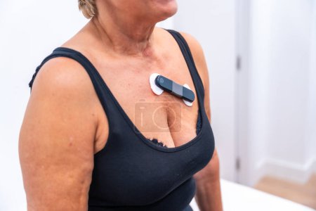 Photo for Woman with cardiac problems undergoing a Ecg Holter monitor test with a innovative device - Royalty Free Image