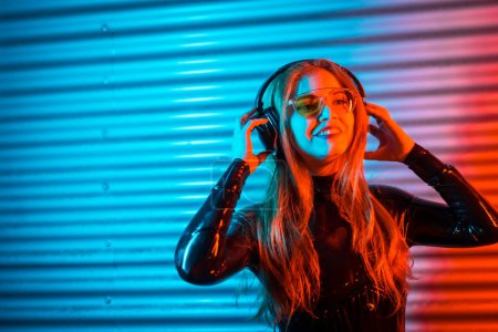 Foto de Foto con espacio de copia de una mujer rubia de belleza usando auriculares para escuchar música por la noche - Imagen libre de derechos
