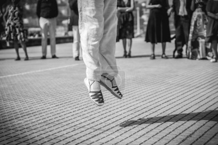 Baskische Tänzerin springt bei einer Feier in einer Stadt im Baskenland, Schwarz-Weiß-Foto