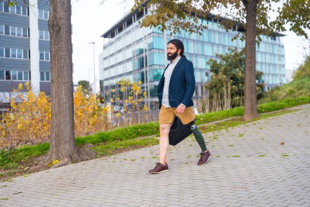 Photo for Photo with copy space of a businessman with amputee leg walking along an urban park - Royalty Free Image