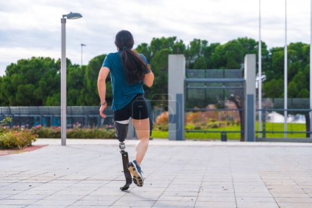 Photo for Rear view of a handicapped runner with a prosthetic leg in a park - Royalty Free Image