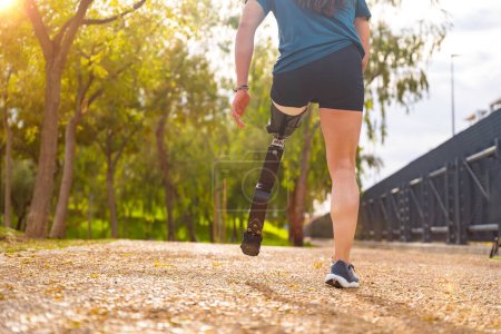 Photo for Close-up rear view of a disabled man with prosthetic leg running outdoors - Royalty Free Image