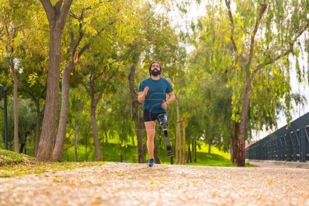 Photo for Low angle view photo with copy space of a disabled athletic man running with prosthetic leg in a park - Royalty Free Image