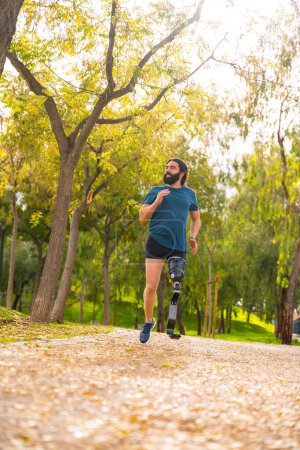 Photo for Vertical photo with low angle view of a man with prosthetic leg running outdoors - Royalty Free Image