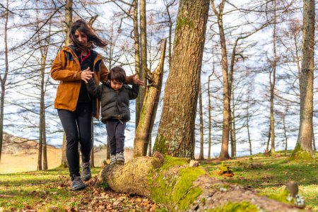 Foto de Madre con su hijo caminando en un árbol en un bosque muy feliz en el Monte Erlaitz en Irún, País Vasco - Imagen libre de derechos