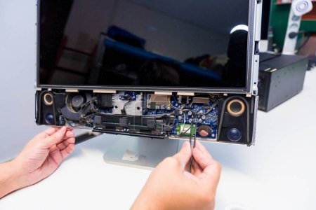 Nahaufnahme der Hände eines IT-Ingenieurs bei der Reparatur eines Computers in einer Werkstatt