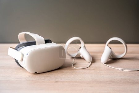 Futuristische weiße Virtual-Reality-Brillen und Kopfhörer auf Holztisch