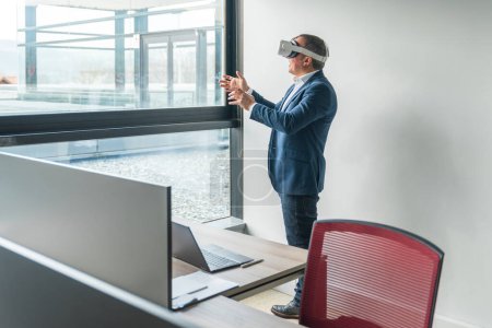 Geschäftsmann mit 3D-Brille bei der Arbeit im Büro vor dem Fenster