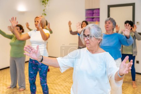 Women moving coordinated closing a qi gong class doing en specific movement to close