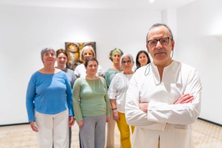 Portrait of a male Qi gong instructor and students in the class