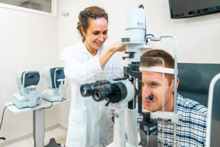 Junger Mann beim Augenarzt lässt sich von Ärztin untersuchen