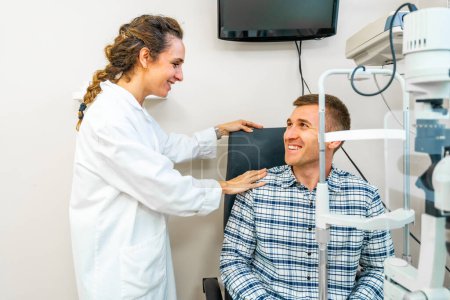 Optométriste féminine amicale réconfortant un patient lors d'un check-up à la clinique