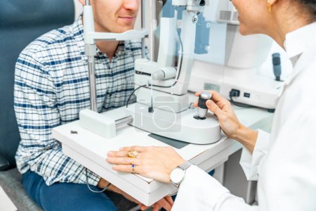 Partie d'un homme méconnaissable vérifiant la vision oculaire dans une clinique d'ophtalmologie