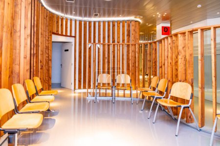 Foto de Sala de espera vacía de una clínica de oftalmología con sillas y muebles de madera - Imagen libre de derechos