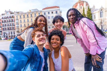 Perspectiva personal de un grupo multiétnico de amigos hablando de un selfie en la ciudad