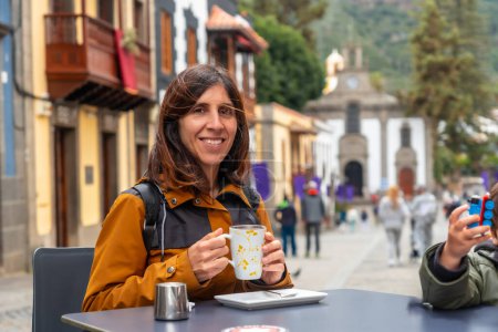 Eine Touristin ruht sich in der Gemeinde Teror aus und trinkt einen Kaffee. Gran Canaria, Spanien