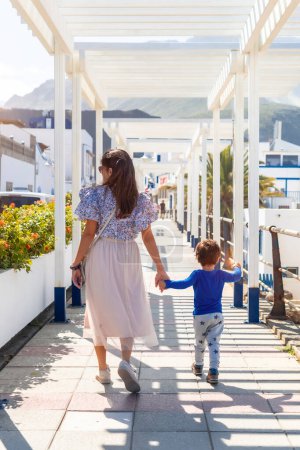 A mother with her son walking on holiday in Puerto de Las Nieves in Agaete on Gran Canaria, Spain