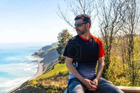 Portrait of a man looking at the beautiful coastal landscape in the flysch of Zumaia, Gipuzkoa. Basque Country